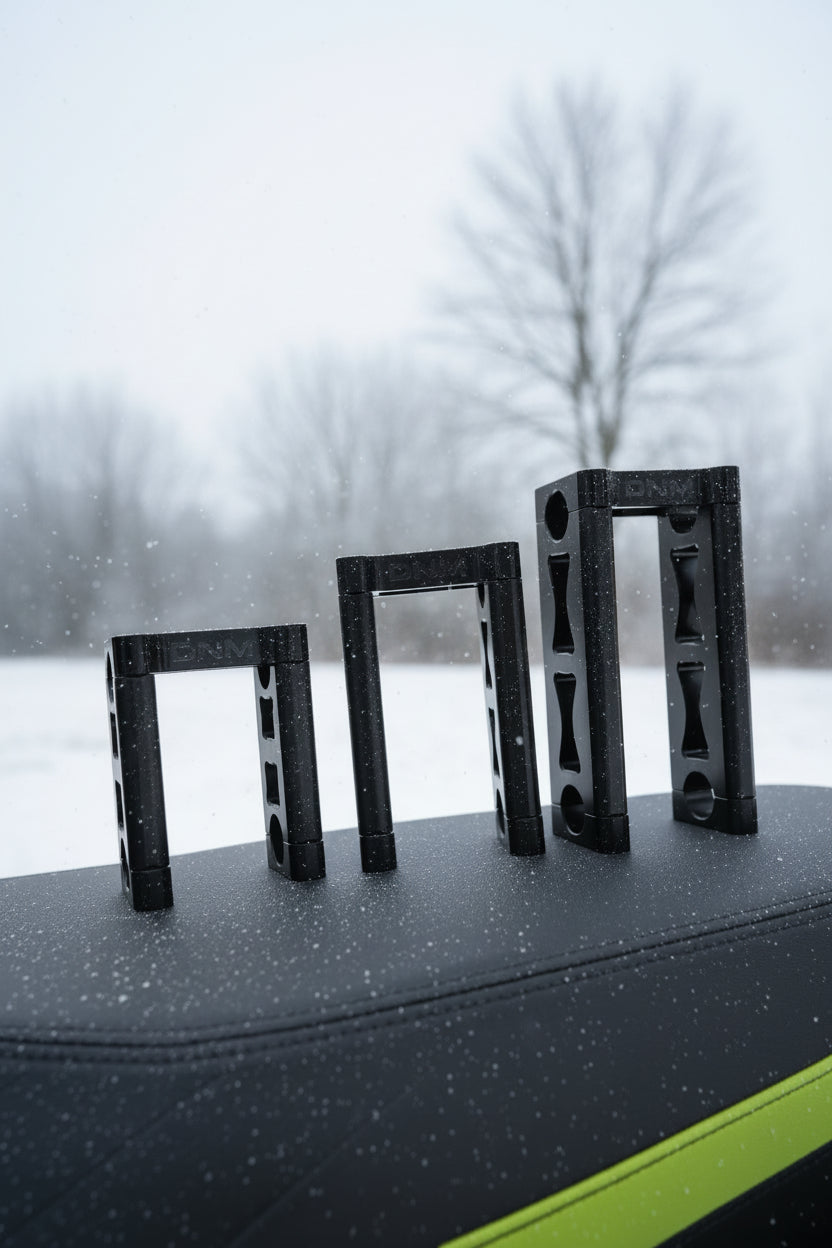 Set of black metal brackets on a cardboard surface